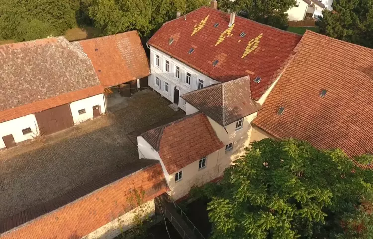 Luftaufnahme von historischen Gebäuden mit roten Dächern und Innenhof