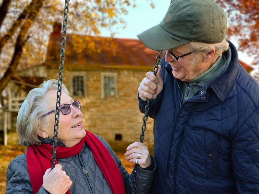 Älterer Mann, der im Freien neben älterer Frau auf Schaukel steht. Foto: Pixabay auf Pexels