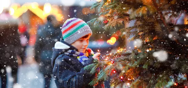 Junge am Weihnachtsbaum draußen